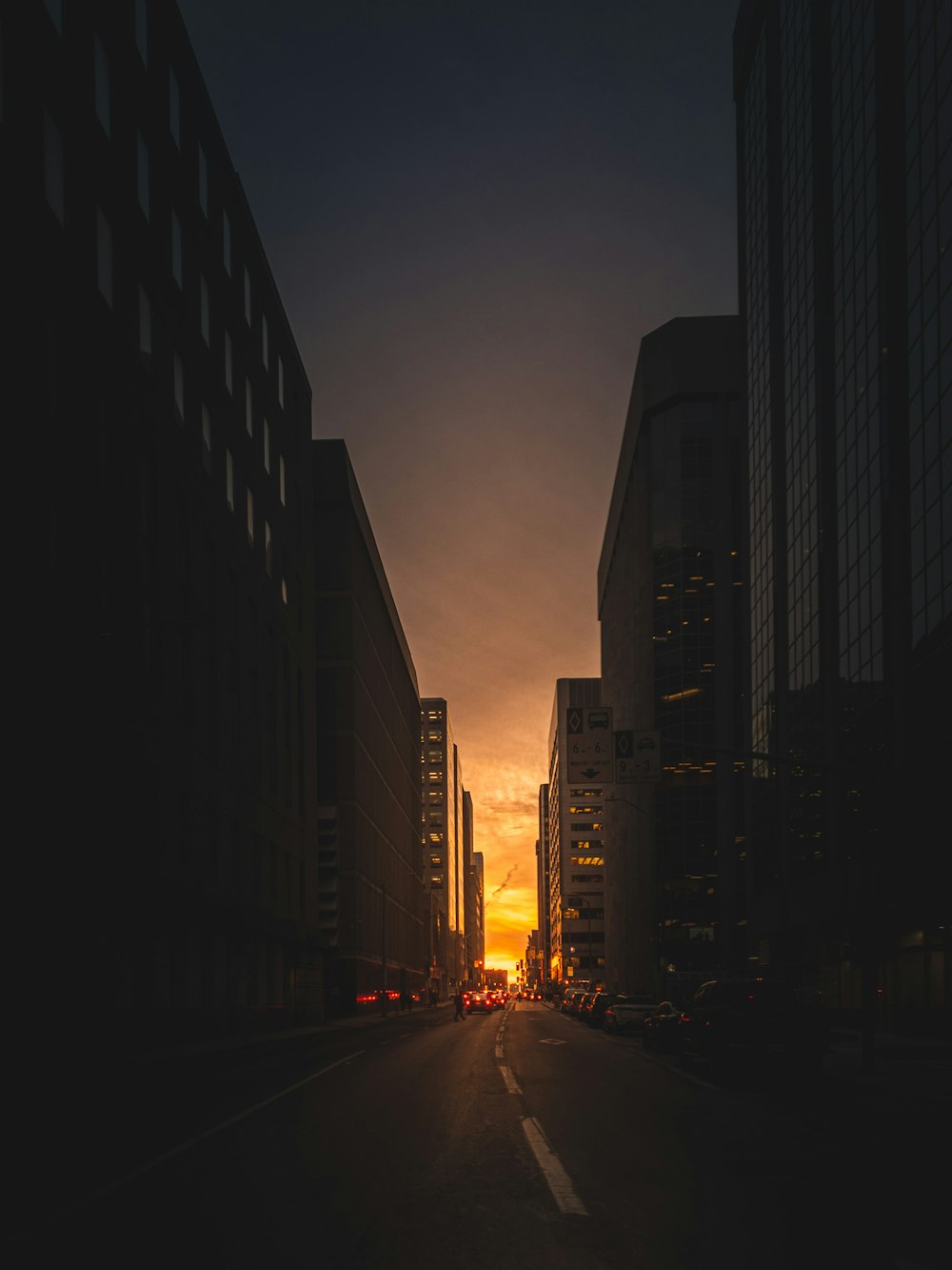 Sehen Sie sich die Fotografie der Straße zwischen den Hochhäusern bei Sonnenaufgang an
