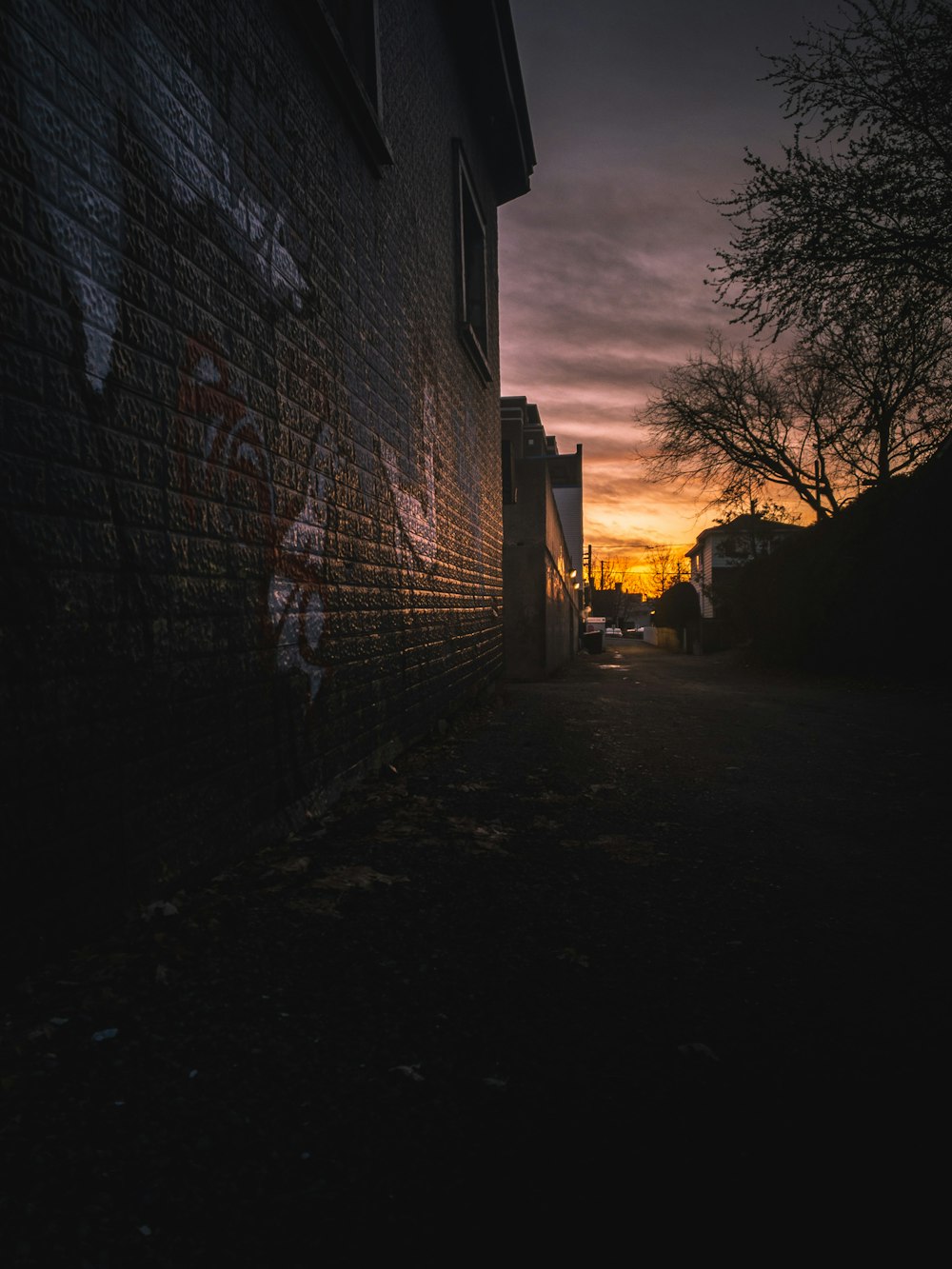 a dark alley with graffiti on the side of it