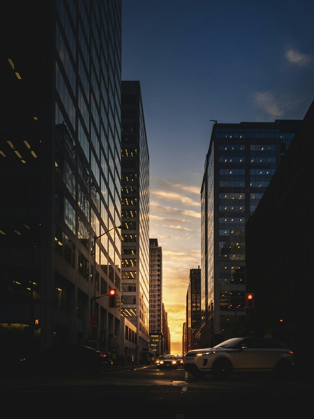 a city street filled with tall buildings at sunset