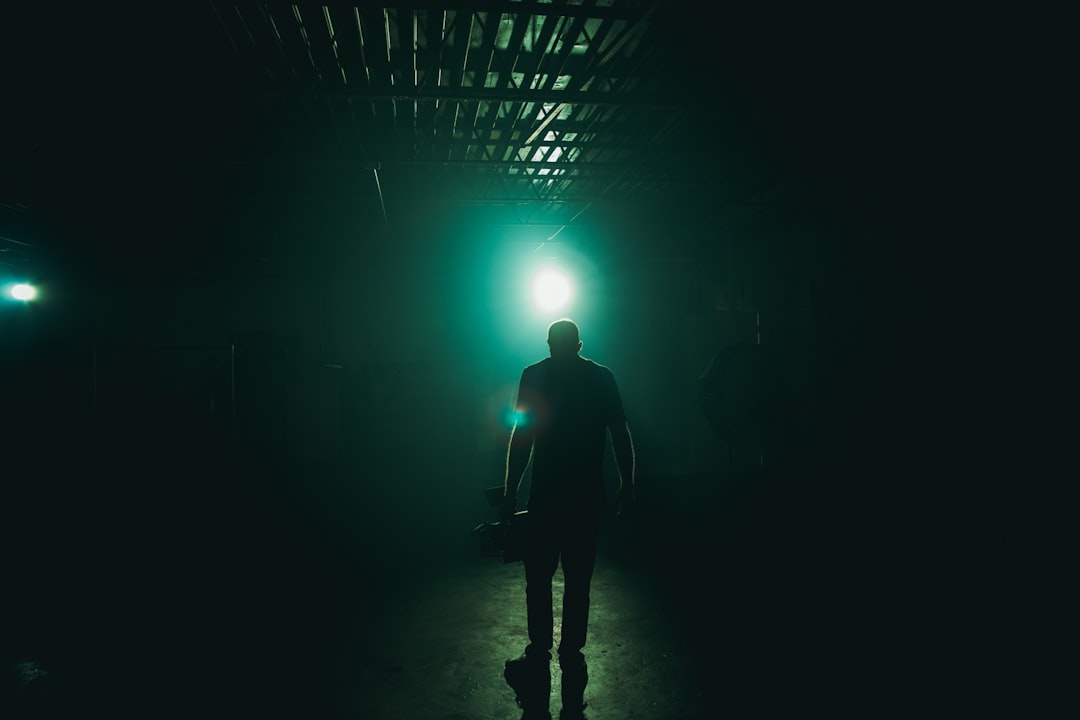 silhouette photography of man holding camera inside building