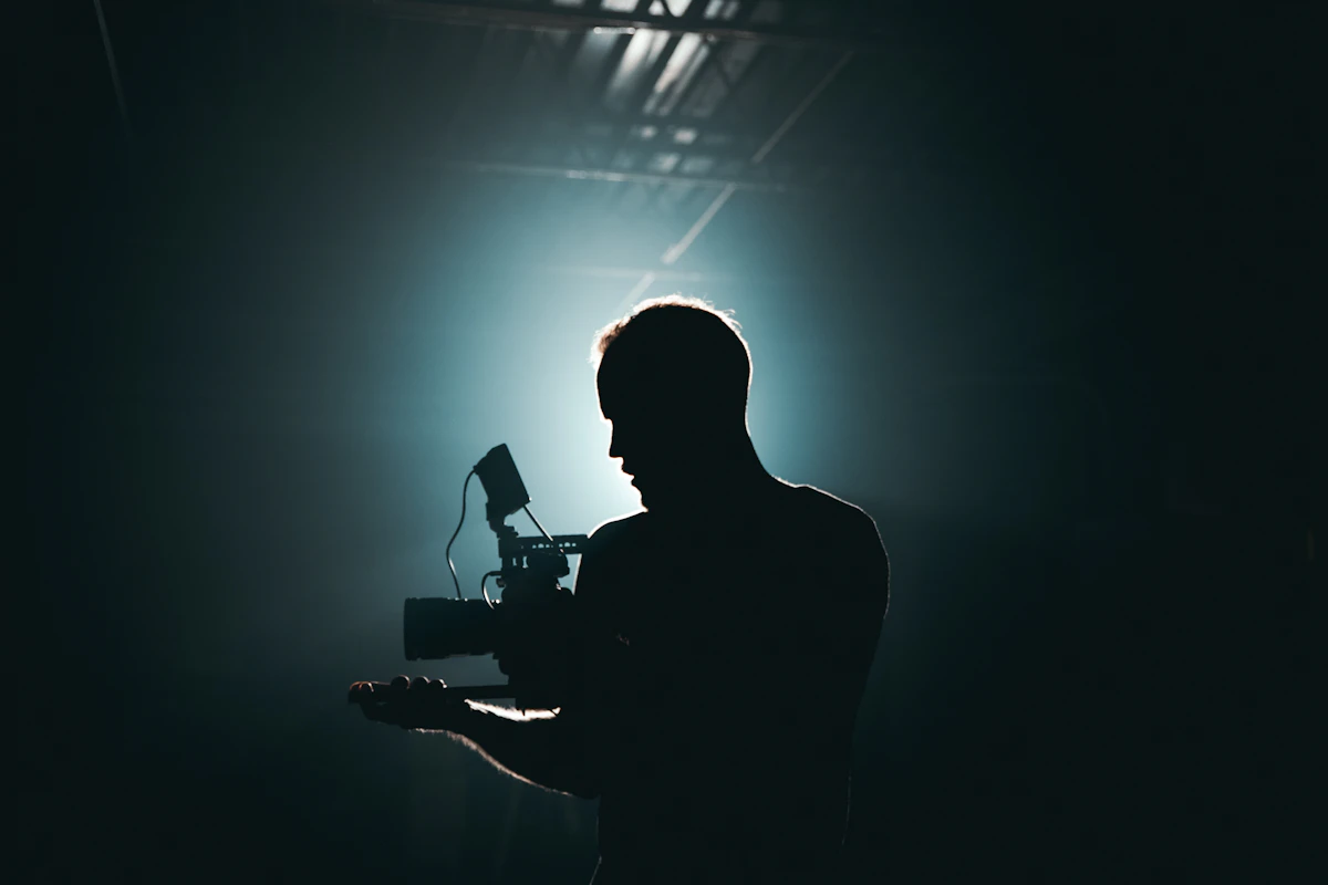 Cinematographer silhouetted in backlight holding a camera