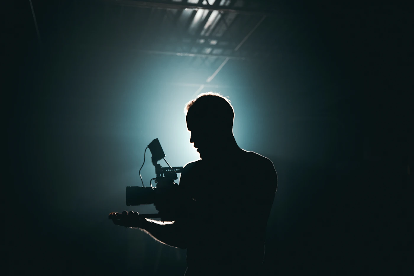 Cinematographer silhouetted in backlight holding a camera
