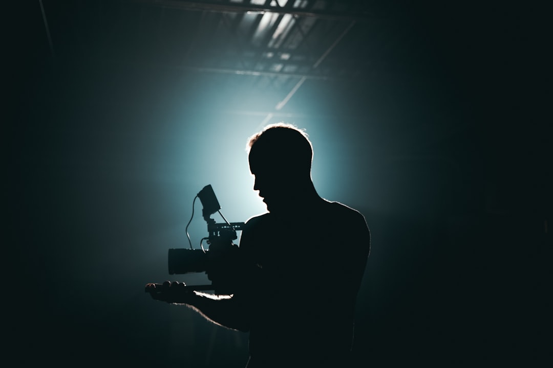 silhouette photography of man holding camera