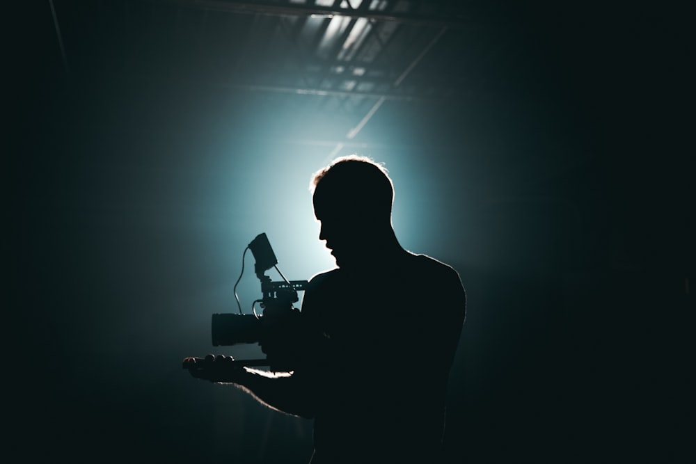 Fotografía de silueta de hombre sosteniendo cámara