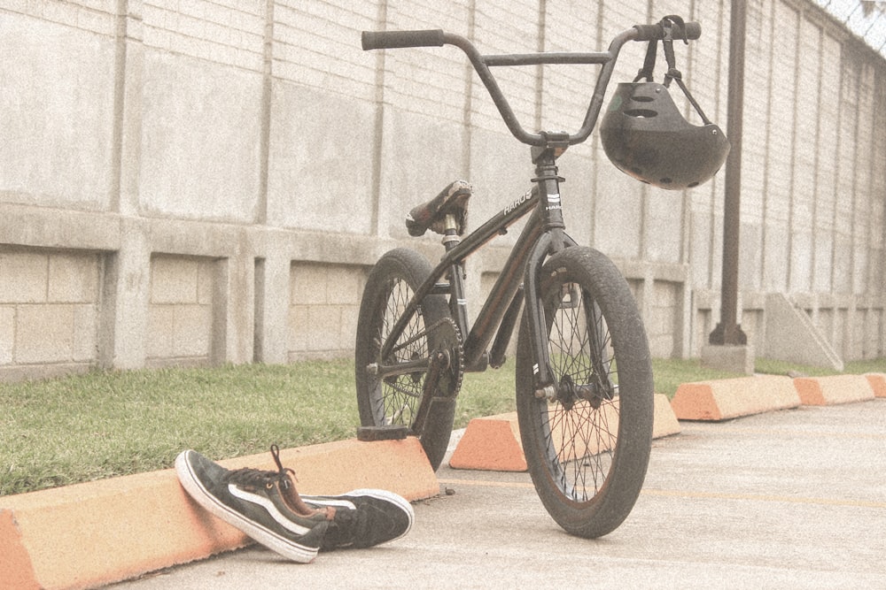 pair of black VANS Original shoes beside BMX bike