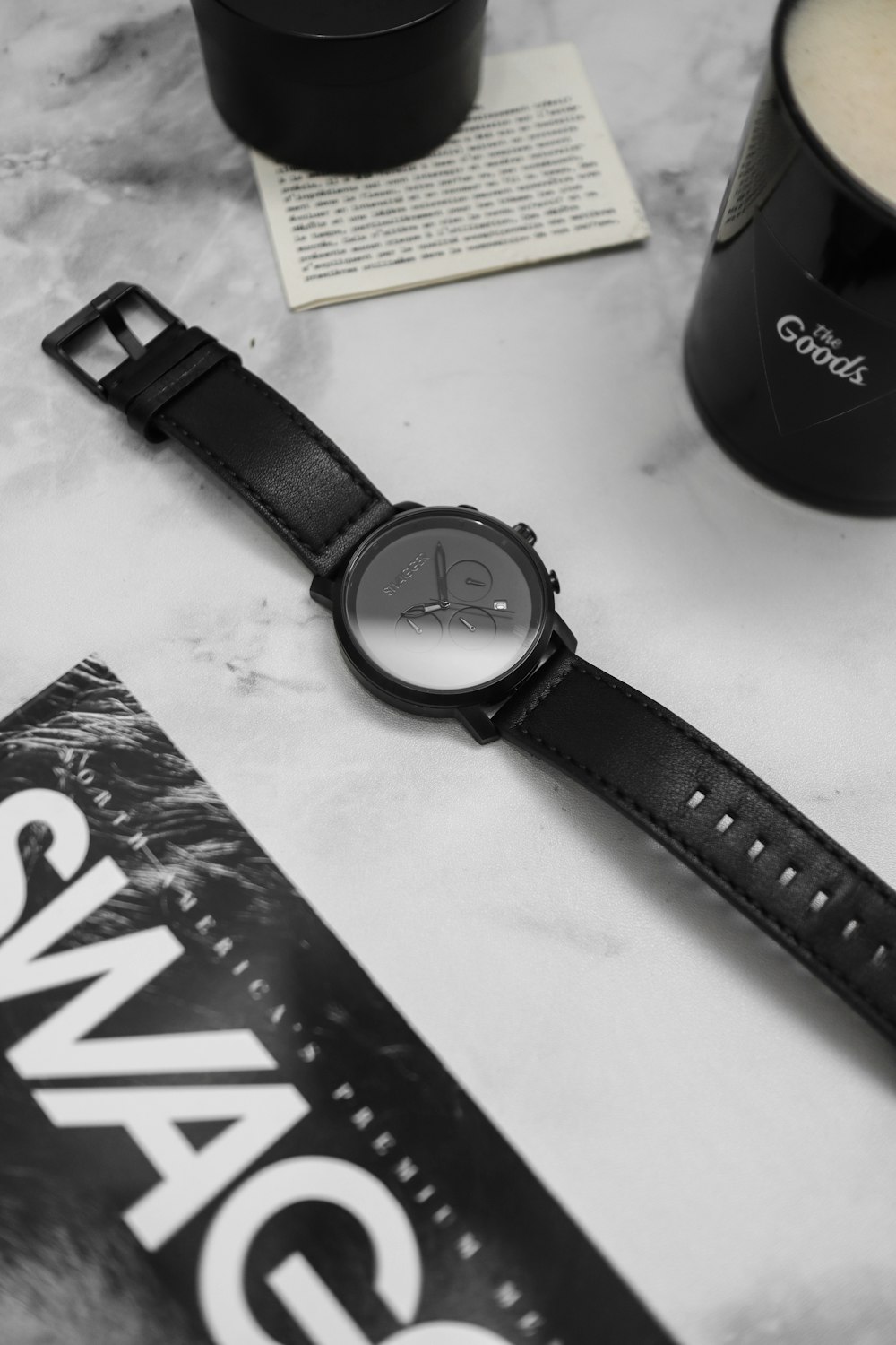 round black analog watch with band beside mug