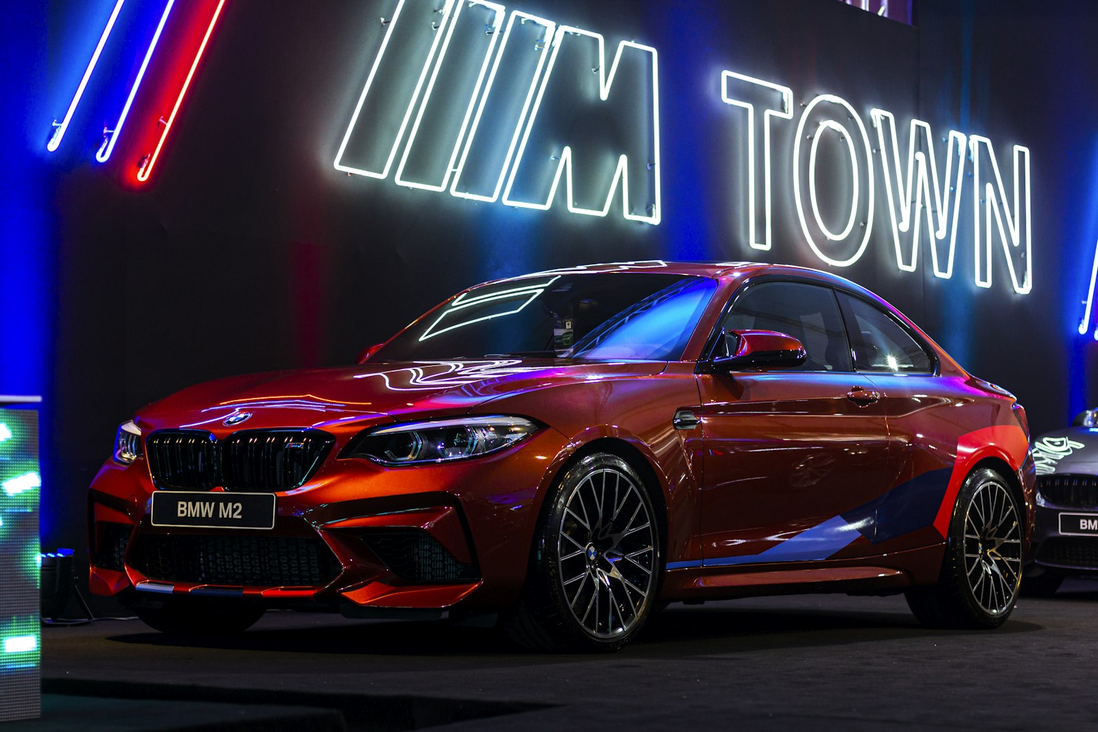 Red BMW M2 (F87) coupe parked outdoors, front three-quarter exterior view