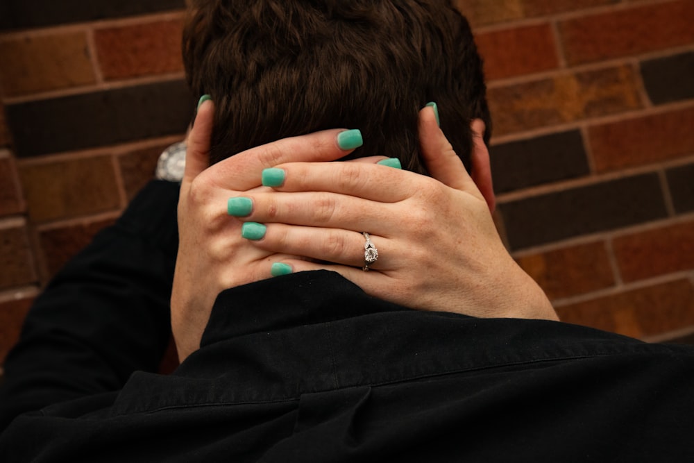 woman with two hands on man's neck