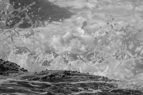 A striking metal print of a rocky shoreline with waves crashing, emphasizing texture and depth.