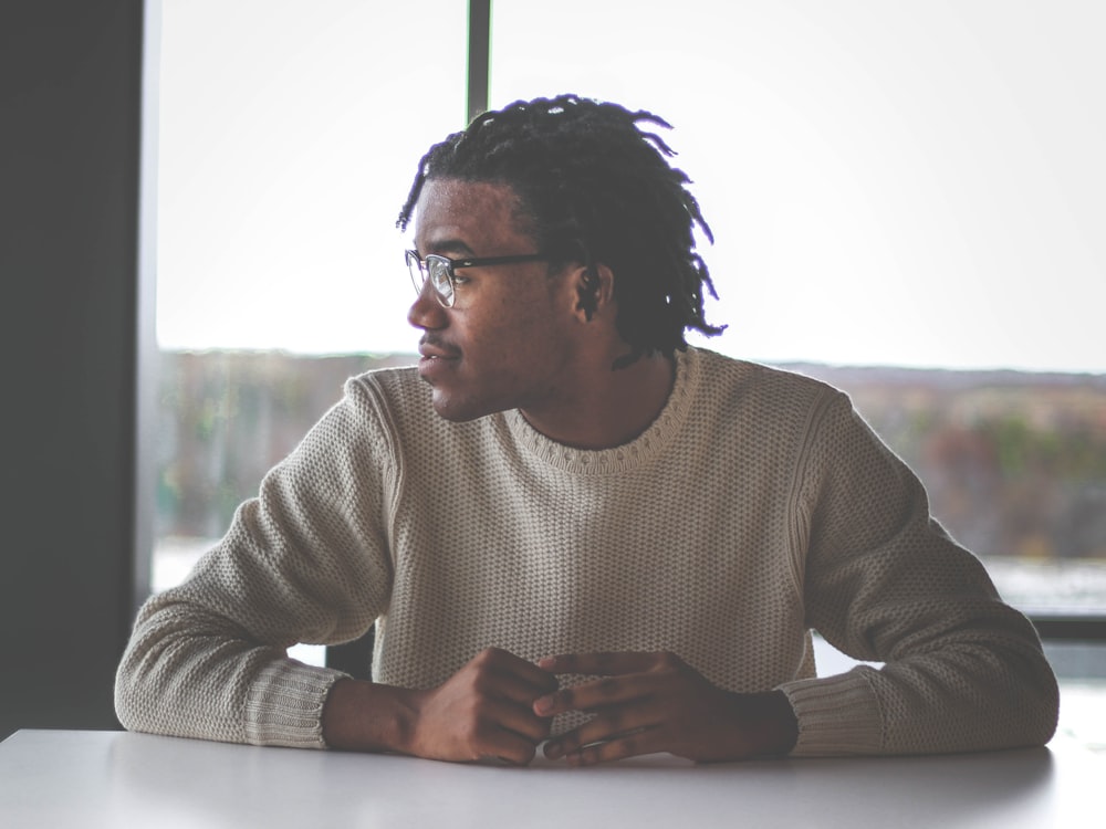 man in white sweater around table