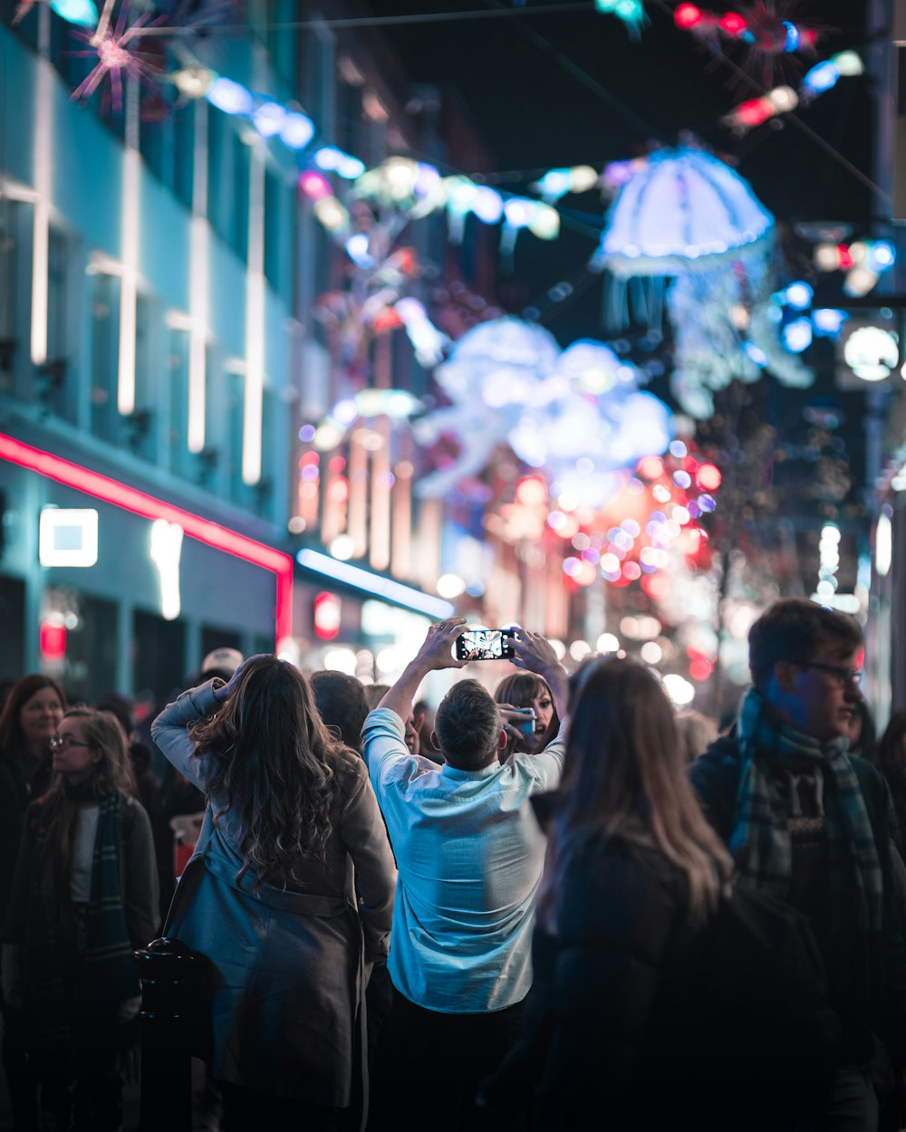 people in city with lights at night