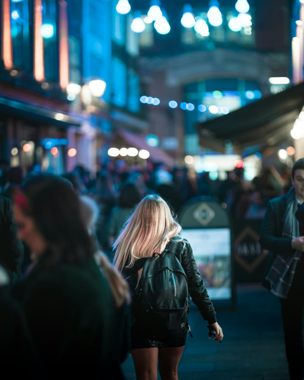 a woman walking down a street at night