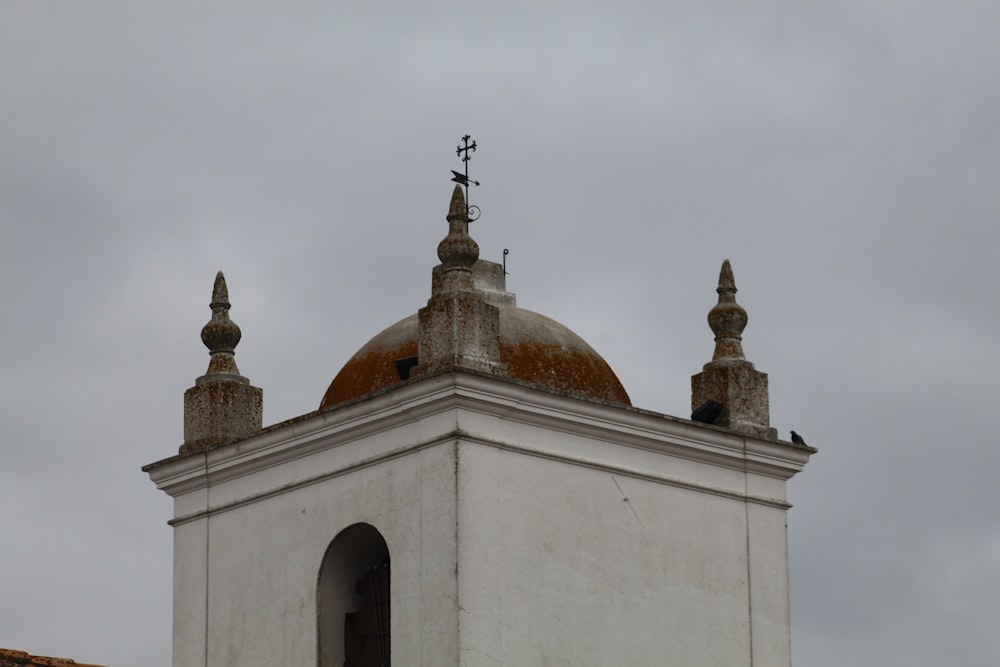 a white building with a brown dome and two crosses on top