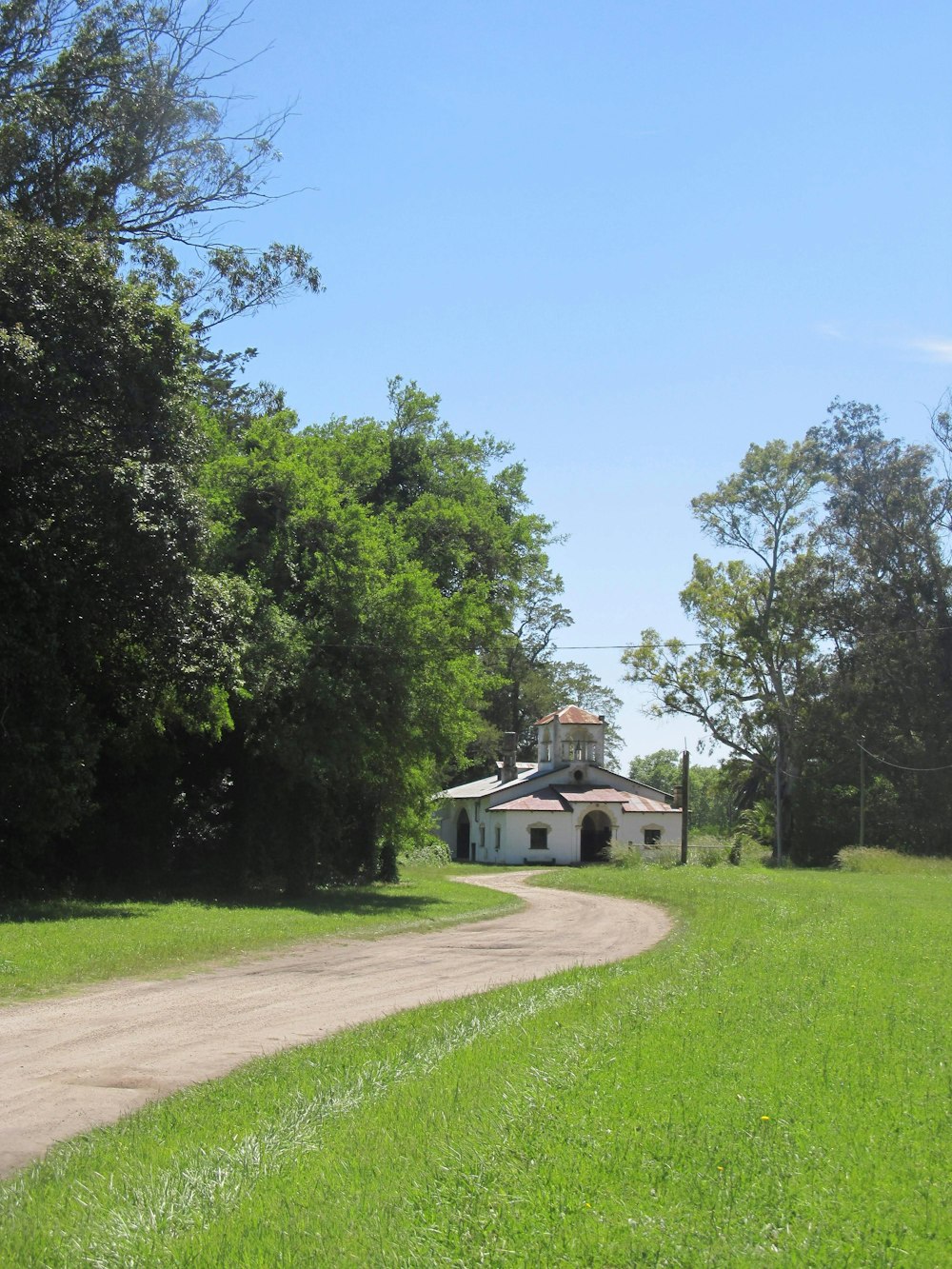 Casa de hormigón blanco cerca de campo de hierba verde