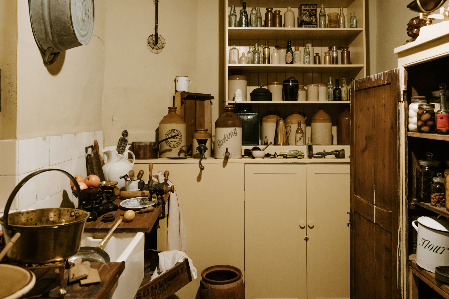 Pantry shelves and cupboards holding jars, bottles, tins and utensils