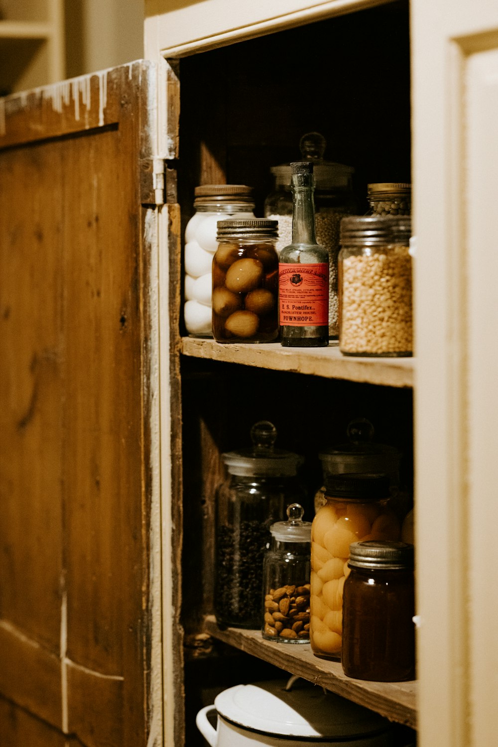 preserve jars on brown wooden shelf