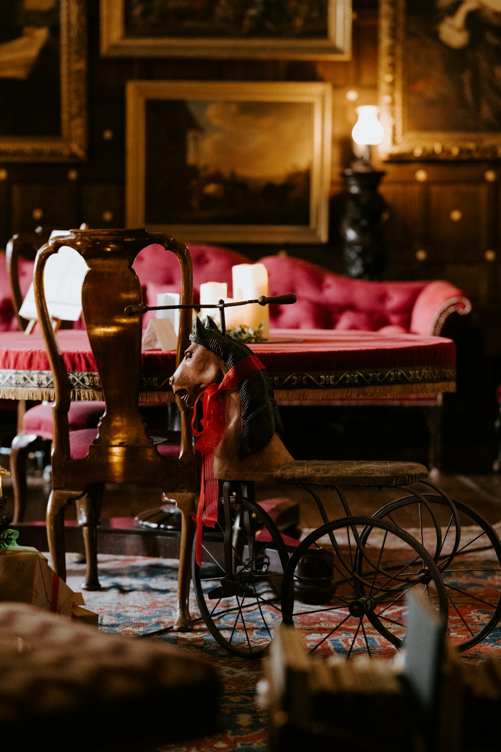 brown wooden chair and red fabric sofa