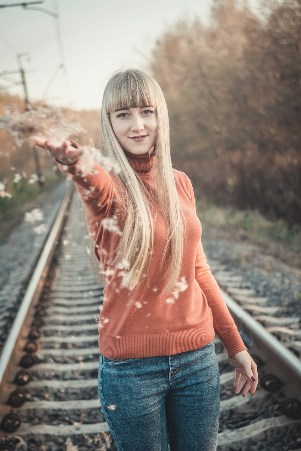 a woman is standing on a train track
