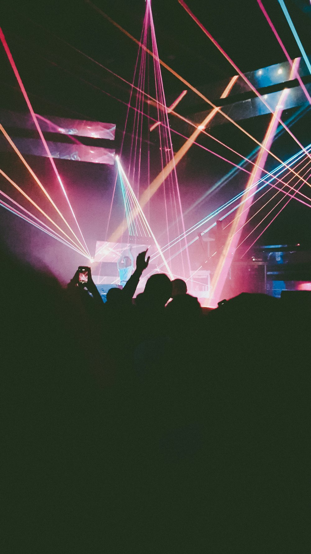 people performing on stage with lights in front of crowd