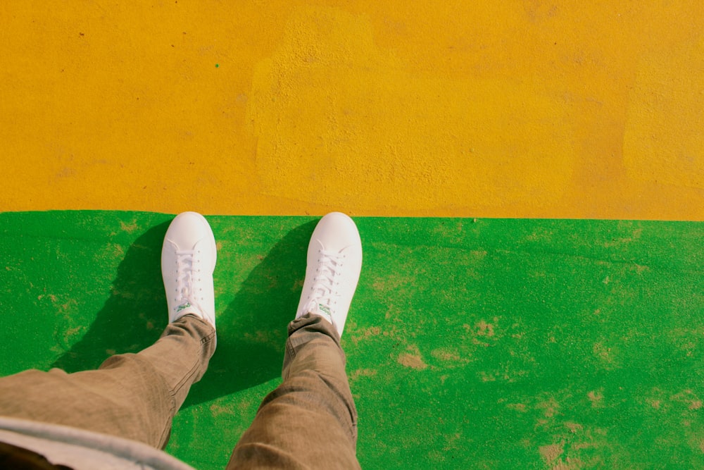 person wearing white lace-up low-top sneakers