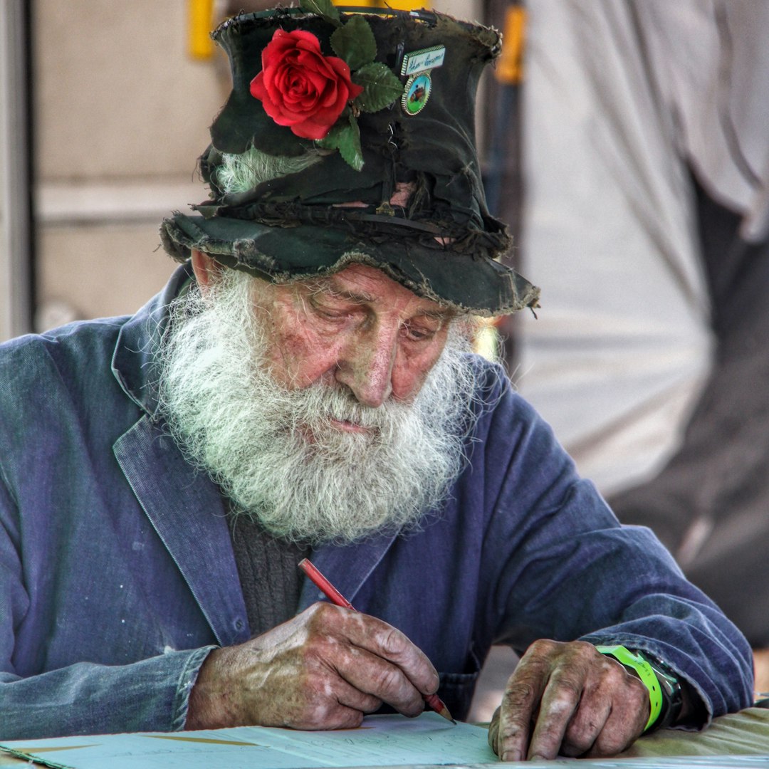 shallow focus photo of man writing on printing paper