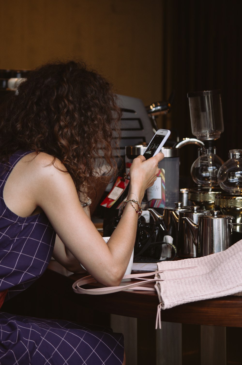 woman sitting on chair while using smartphone