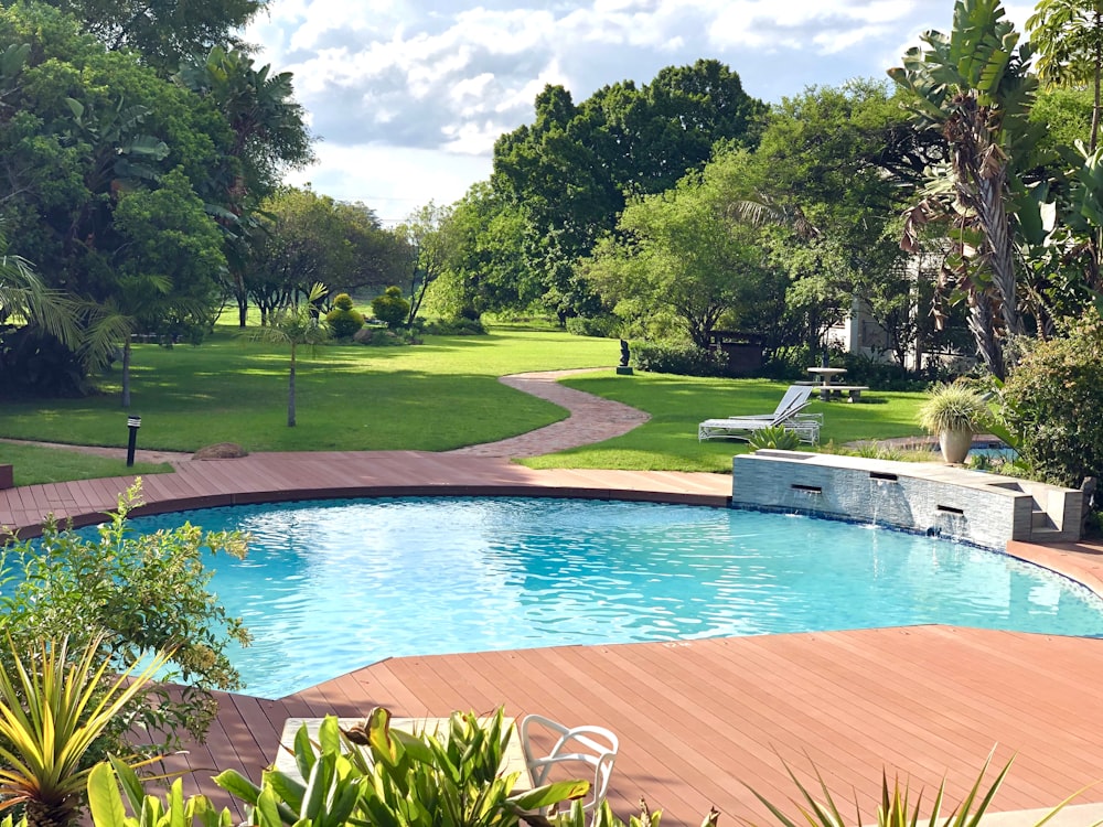 swimming pool with brown frame and pathway near trees during day