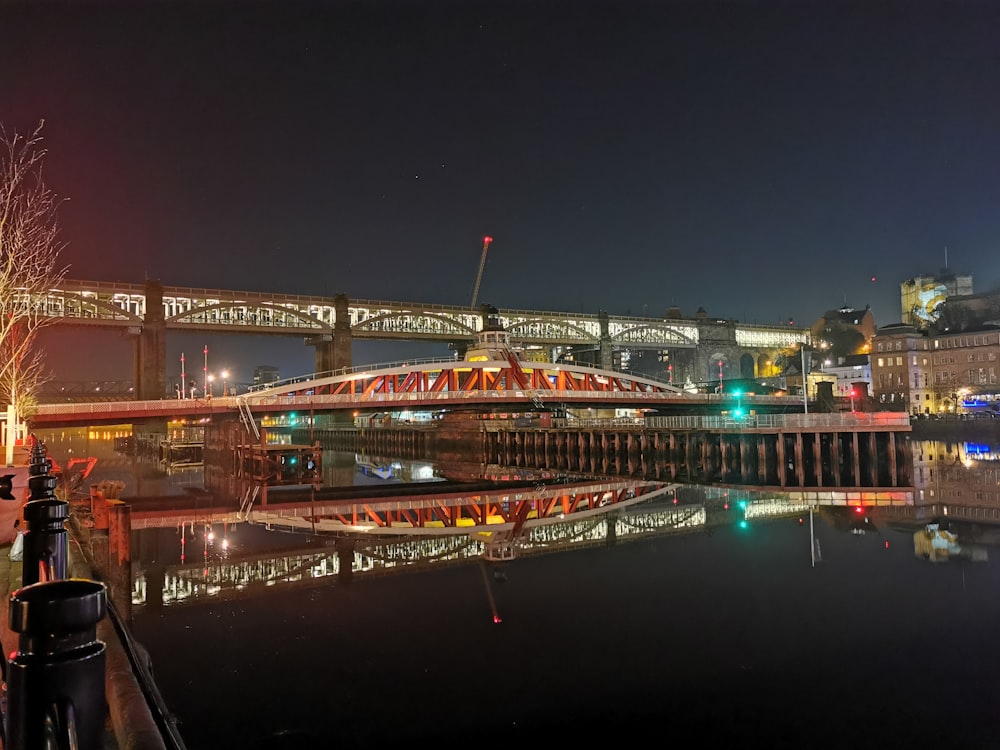 reflection of bridges on body of water at night