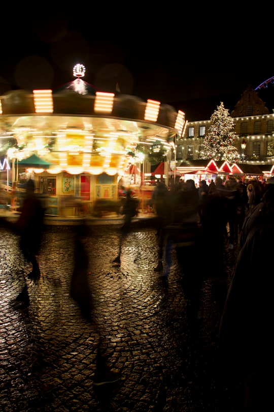 walking people near carousel at night in Düsseldorf Germany