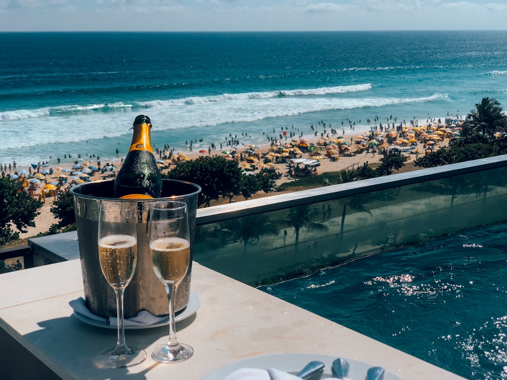 champagne glasses beside bucket with bottle