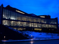 Evening shot of the institute building illuminated with blue and white lights, reflecting the brand colors.
