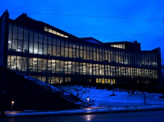 Evening shot of the institute building illuminated with blue and white lights, reflecting the brand colors.