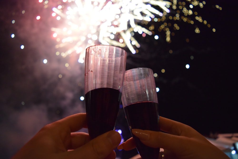 two person holding glass flutes