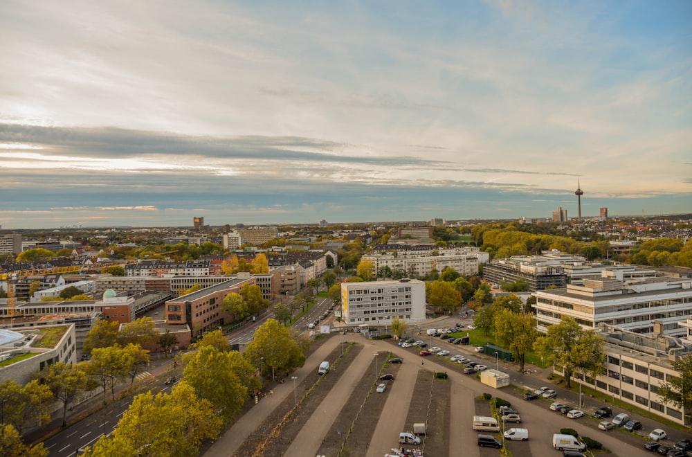 aerial photography of different vehicles on road near buildings under blue and white sky