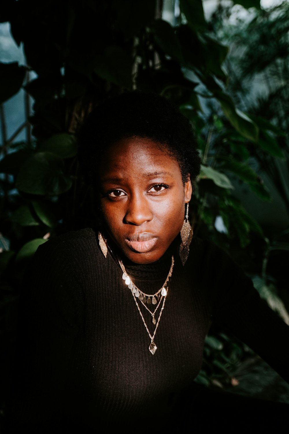 woman wearing black top and silver-colored necklaces