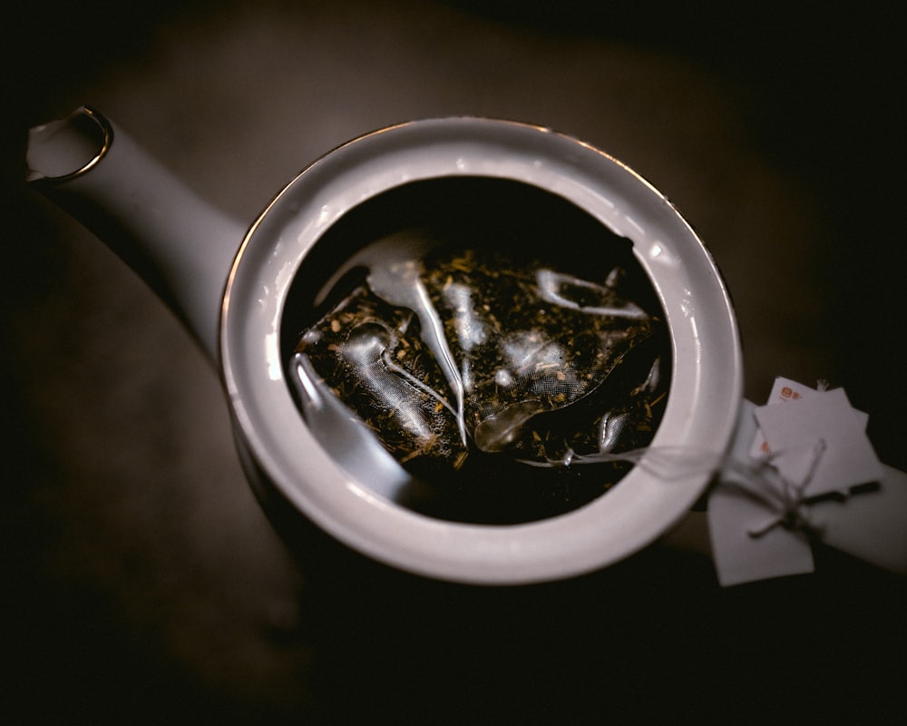 macro photography of tea bag in white ceramic teapot