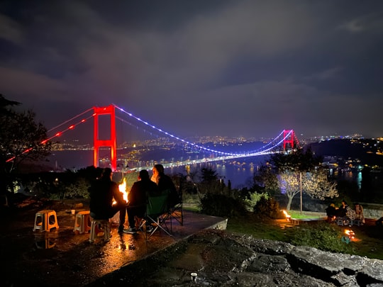 three person doing picnic near the Golden Gate bridge in Rumeli Hisarı Turkey