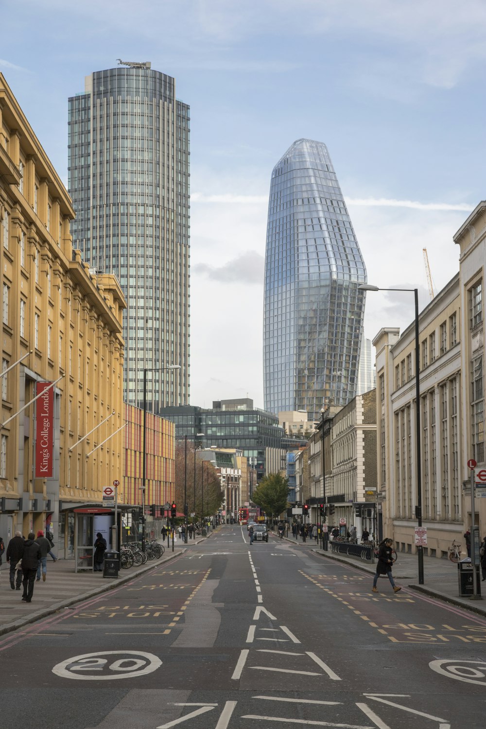 people walking on road between buildings during daytime