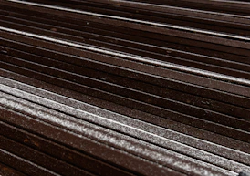 a close up of a wooden bench with snow on it