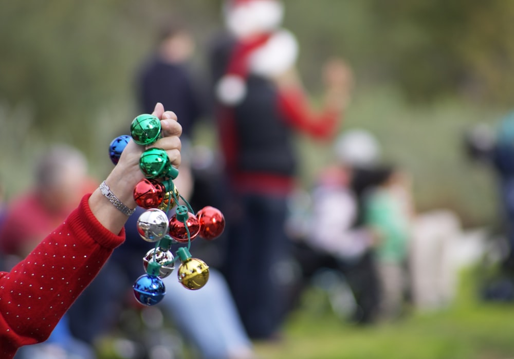 person holding multicolored baubles