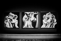 Black and white photographs of classical sculptures depict groups of intertwined figures. The images capture the artistic representation of human forms with detailed attention to anatomy and emotion. The figures exhibit intricate expressions and gestures that communicate intimacy and fluidity.