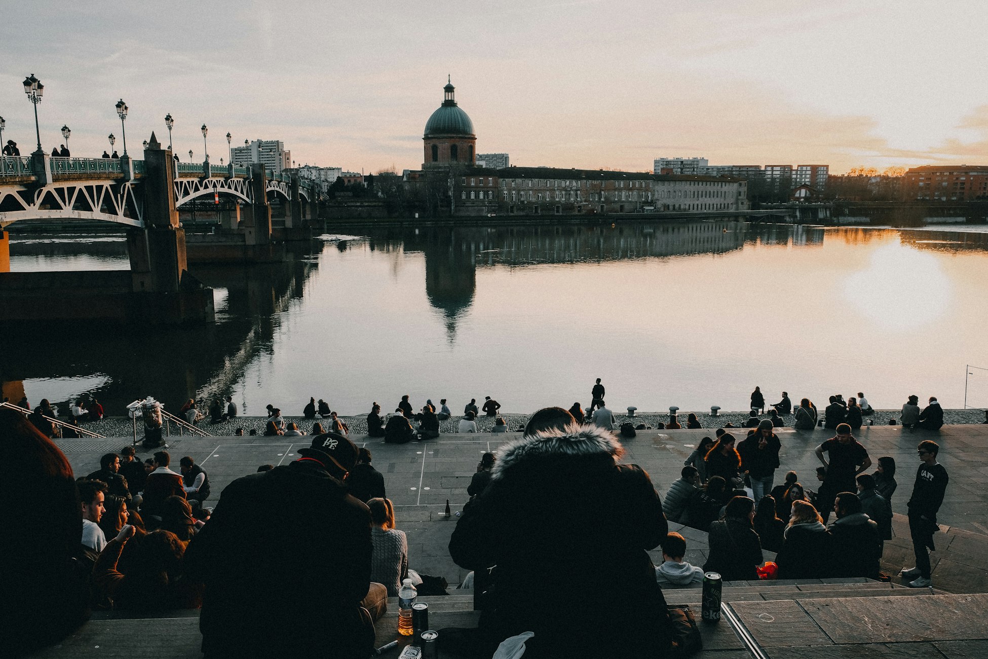 people sitting by a canal in Toulouse, France