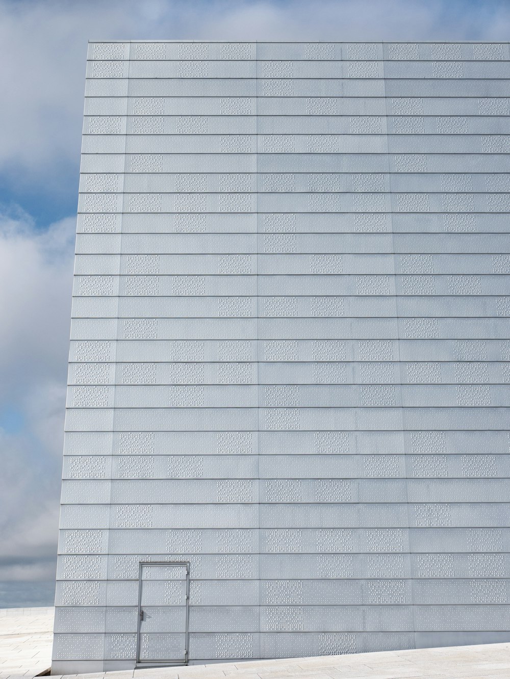 um edifício branco alto com um portão de metal à sua frente