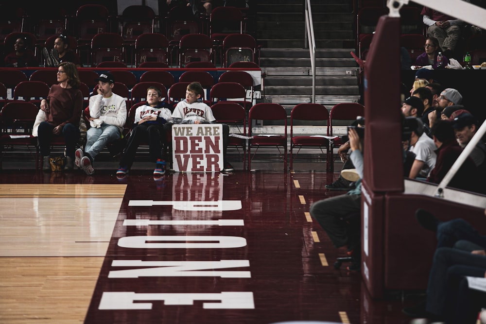 people sitting on individual chairs while watching basketball game