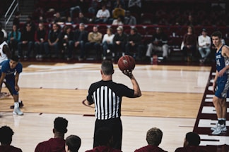 basketball referee holding ball and about to throw it to a player