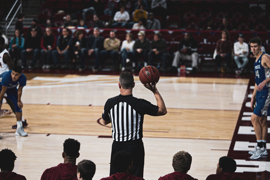 basketball referee holding ball and about to throw it to a player