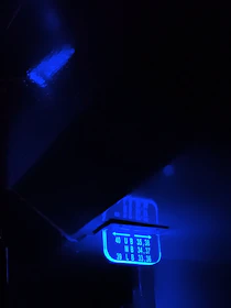 A dynamic digital scoreboard glowing with neon blue and green lights against a dark background.