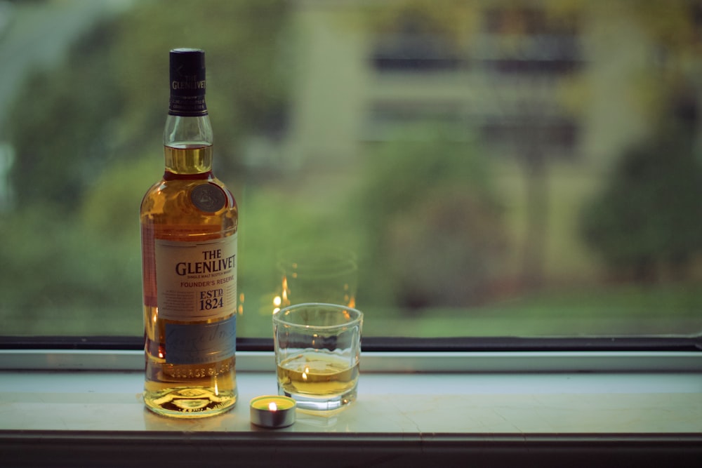 La bottiglia di whisky Glenlivet vicino al vetro