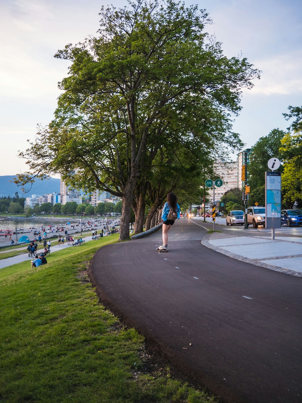 people walking on park viewing high-rise buildings under white and blue sky