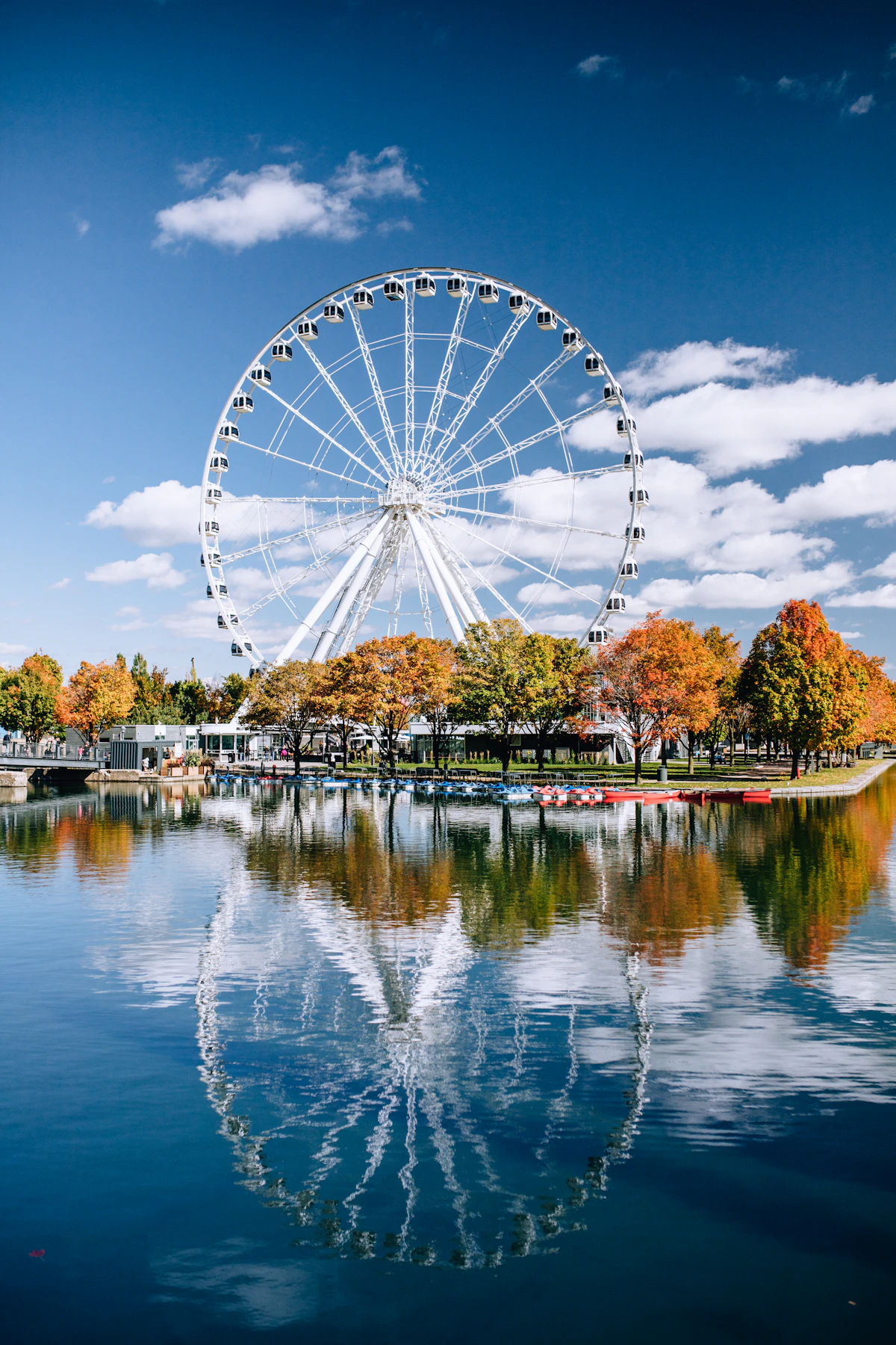 The Montréal Observation Wheel reflected in the Old Port water during autumn
